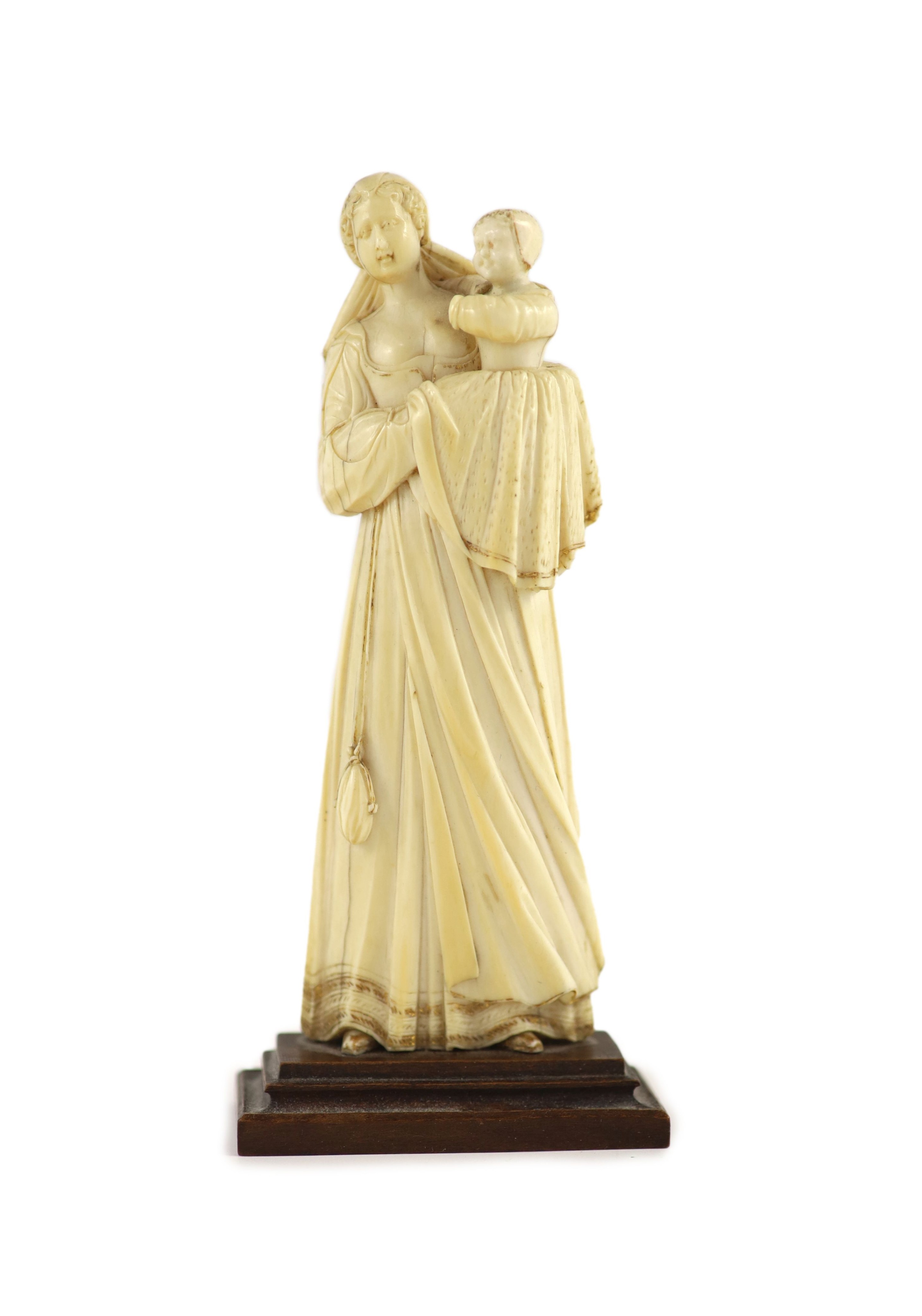 A 17th century French ivory group of a mother and child Height overall 14.5cm.
